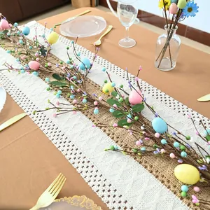 Detail view of colorful Easter egg and berry garland on a decorated dining table