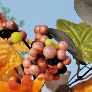 Macro view of artificial autumn berries and maple leaves for harvest festival decor