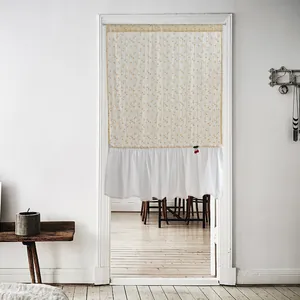 Detailed view of white cotton door curtain with yellow pattern and stylish ruffle hem