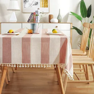 Nappe élégante en lin à rayures avec des pompons décoratifs dans une salle à manger