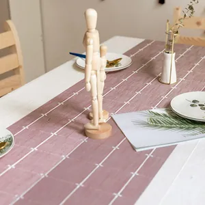 Eleganter Tischläufer aus Stoff mit rosa Karomuster in einer minimalistischen Esszimmerszene