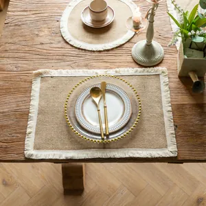 Detailed view of farmhouse vintage jute placemat with elegant white fringe tassels.