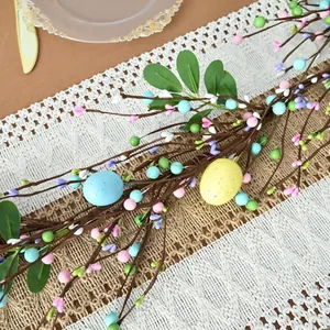 Detailed view of colorful Easter egg and berry garland on a lace table runner decor