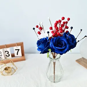 Détail d'un bouquet de roses bleues artificielles avec baies rouges pour l'Independence Day