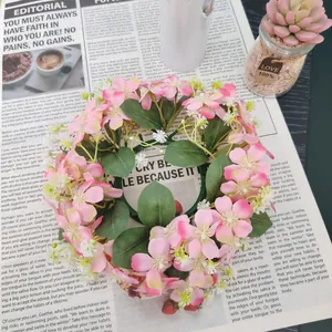 Detail view of artificial pink wild flower wreath with green leaves on newspaper