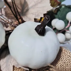 Detailed view of a white artificial pumpkin with maple leaves for harvest festival decor