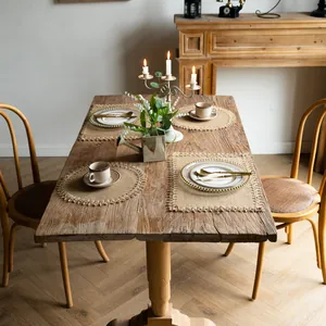 Rustic vintage jute fringed placemats displayed on a farmhouse wooden dining table.