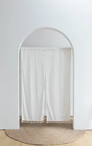 Minimalist white Japanese door curtain with yellow polka dots and elegant tassel fringe detail