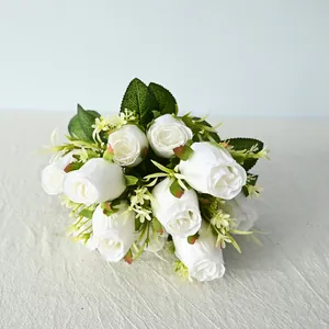 Detalle de la textura de los pétalos y el follaje de un ramo de rosas blancas falsas.