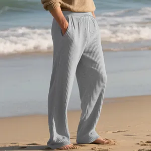 Close-up of men's gray ribbed textured drawstring pants in a relaxed beach setting