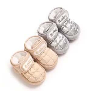 Warme Baby-Winterschuhe aus Baumwolle in Silber und Beige mit Steppmuster und Klettverschluss.