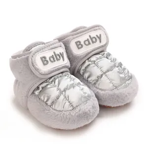Nahaufnahme von grauen und silbernen warmen Winterbabyschuhen mit Plüsch