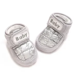 Detailaufnahme von warmen silbernen gesteppten Baby-Winterstiefeln mit weichem Plüsch