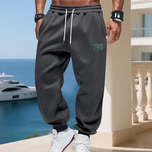 Detailed view of men's loose dark grey fleece-lined joggers with drawstring elastic waist