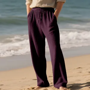 Close-up of men's loose purple jacquard pleated trousers with drawstring at the beach