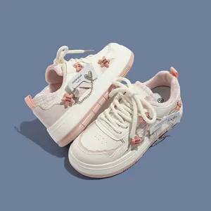 Detailansicht weißer Mädchen-Plateau-Sneaker mit rosa Sternen und süßen Herzanhängern.