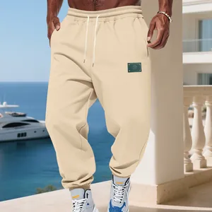 Close-up of beige fleece men's joggers featuring a waist drawstring and ankle cuffs.
