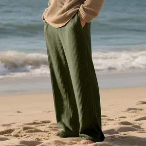 Macro view of olive green ribbed striped wide-leg pants for men on a sandy beach