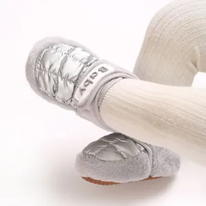 Detail von silbernen, gesteppten Baby-Winterstiefeln mit grauem Webpelzbesatz