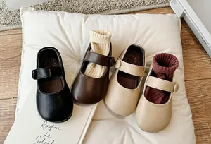 Close-up of toddler girls Mary Jane shoes in black, brown and beige colors.
