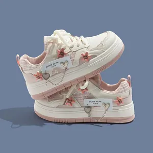 Detailansicht der weißen und rosa Plateau-Sneaker für Mädchen mit Stern- und Herzanhängern