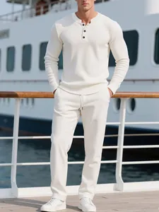 Mann in weißem langärmeligem Cord-Henley-Shirt auf einem luxuriösen Bootsdeck
