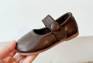 Close-up of soft brown leather princess shoes for girls with elegant round buckle