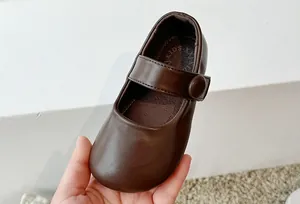 Close-up detail of classic brown leather Mary Jane princess shoes for little girls