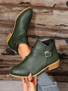 Detailopname van donkergroene Chelsea-boots voor dames met gesp aan de zijkant en rits