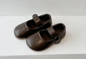 Detail of dark brown children's Mary Jane shoes with soft soles and buckle strap.