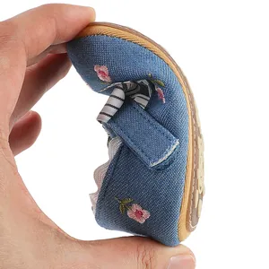 Close-up demonstrating the flexible and soft sole of these blue denim floral baby girl shoes.