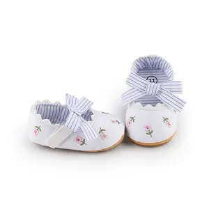 White baby girl princess walking shoes with floral embroidery and blue striped bow detail.