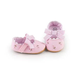 Close-up of pink baby girl princess shoes with floral embroidery and bow