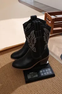 Vue détaillée montrant le poids des bottes de cow-boy noires brodées avec col en V.