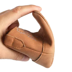Vue détaillée d'une chaussure de bébé marron souple montrant la semelle facile à plier