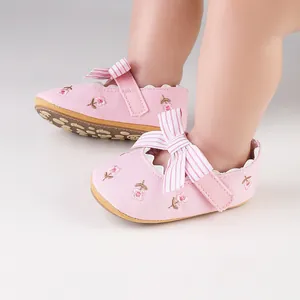 Close-up detail of pink baby girl princess shoes with floral embroidery and bow