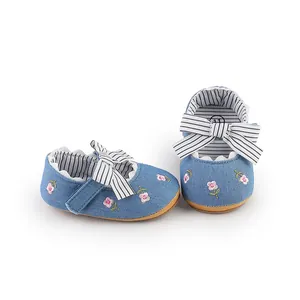 Detail of baby girl blue denim princess walker shoes featuring floral embroidery and bow