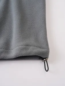 Detalle de sudadera de forro polar gris con dobladillo ajustable con cordón