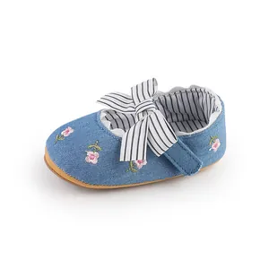 Detailed view of blue baby girl princess shoes with floral embroidery and striped bow