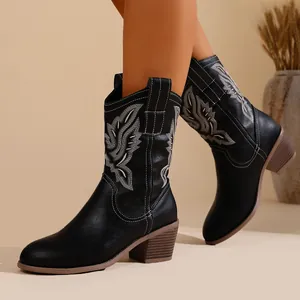 Détail des bottes de cowboy noires brodées avec talons blocs et découpe en V.