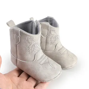 Gros plan détaillé de bottines grises à semelle souple pour bébé, style cowboy ouest
