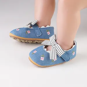 Close-up of blue floral embroidered baby girl walker shoes featuring a cute striped bow.