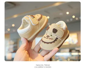 Hochwertige Nahaufnahme beige Cartoon-Hund-Lauflernschuhe mit weichen rutschfesten Sohlen.