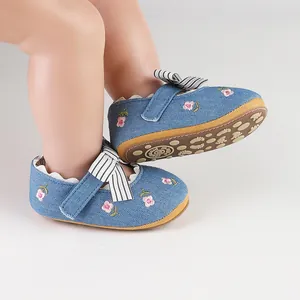 Detail view of baby girl walking shoes with pink flower embroidery and striped bow