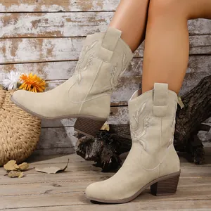 Détail de bottes de cowboy beiges brodées pour femmes avec talons épais et coupe en V