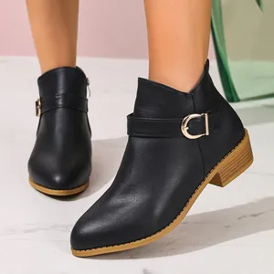 Close-up van zwarte Chelsea boots voor dames met gesp en ritssluiting opzij