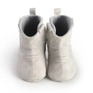 Vue détaillée de bottines de cowboy grises pour bébé avec broderies et semelles souples.