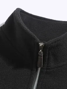 Detalle de sudadera de forro polar negro para hombre con cuello alto y cremallera.
