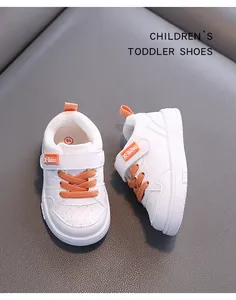 White toddler sneakers with orange accents and soft non-slip soles for ages 1-3
