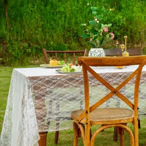 Nappe rectangulaire en dentelle blanche élégante sur une table en bois dans un jardin